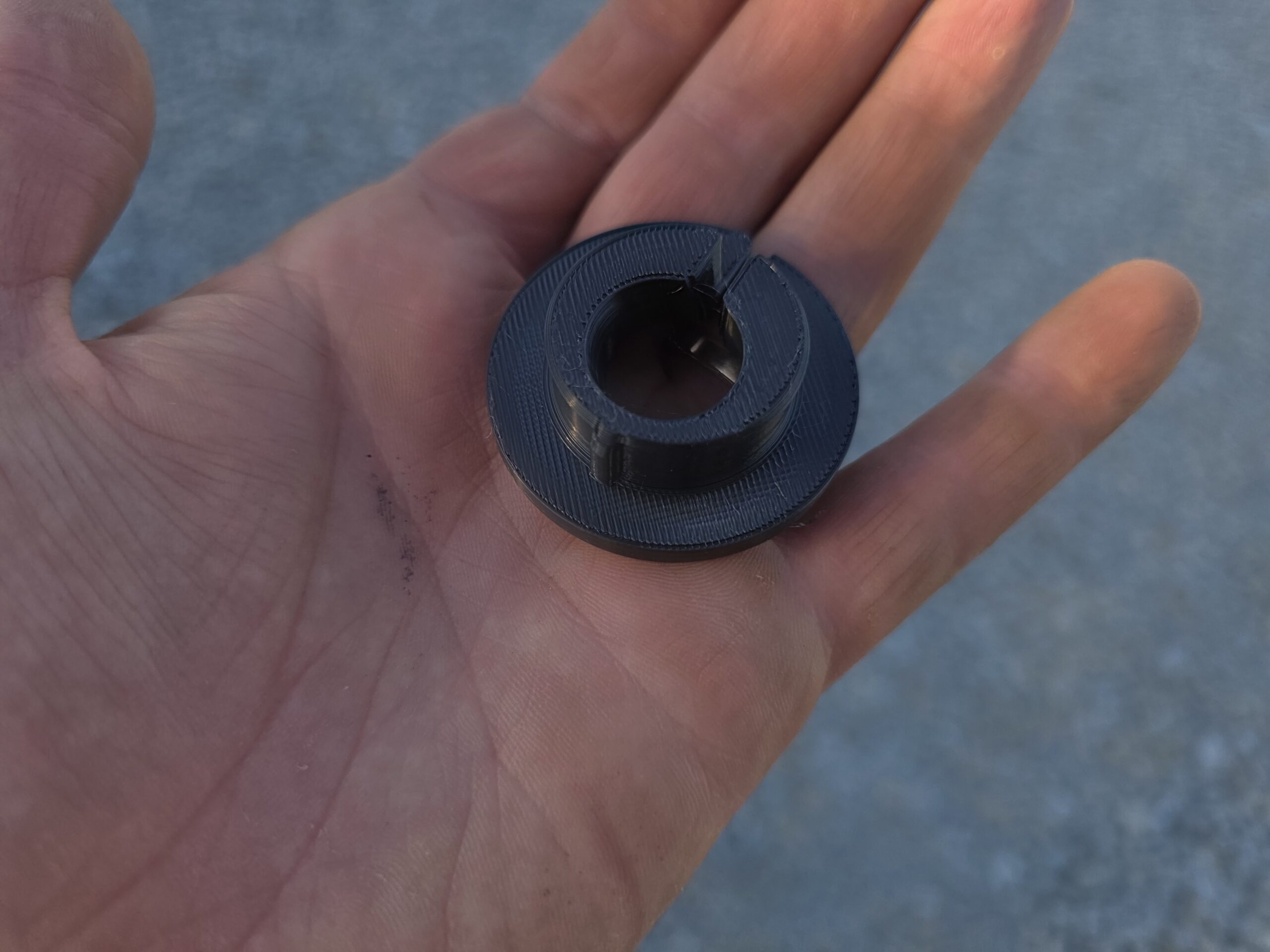 Must ümmargune plastdetail käes